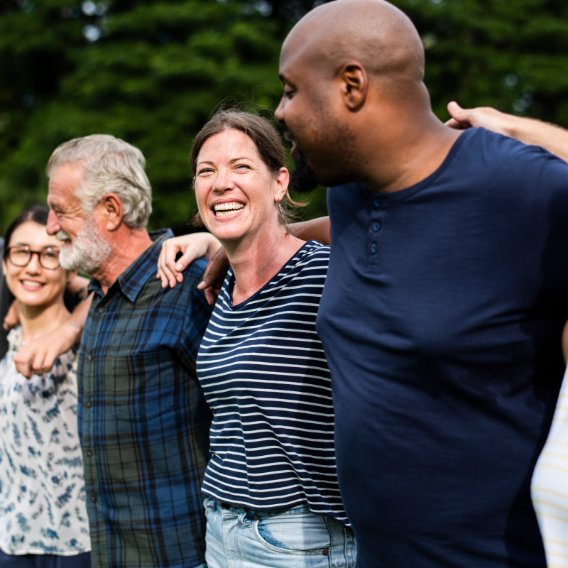 A group of people smiling together as they are a team helping their community 