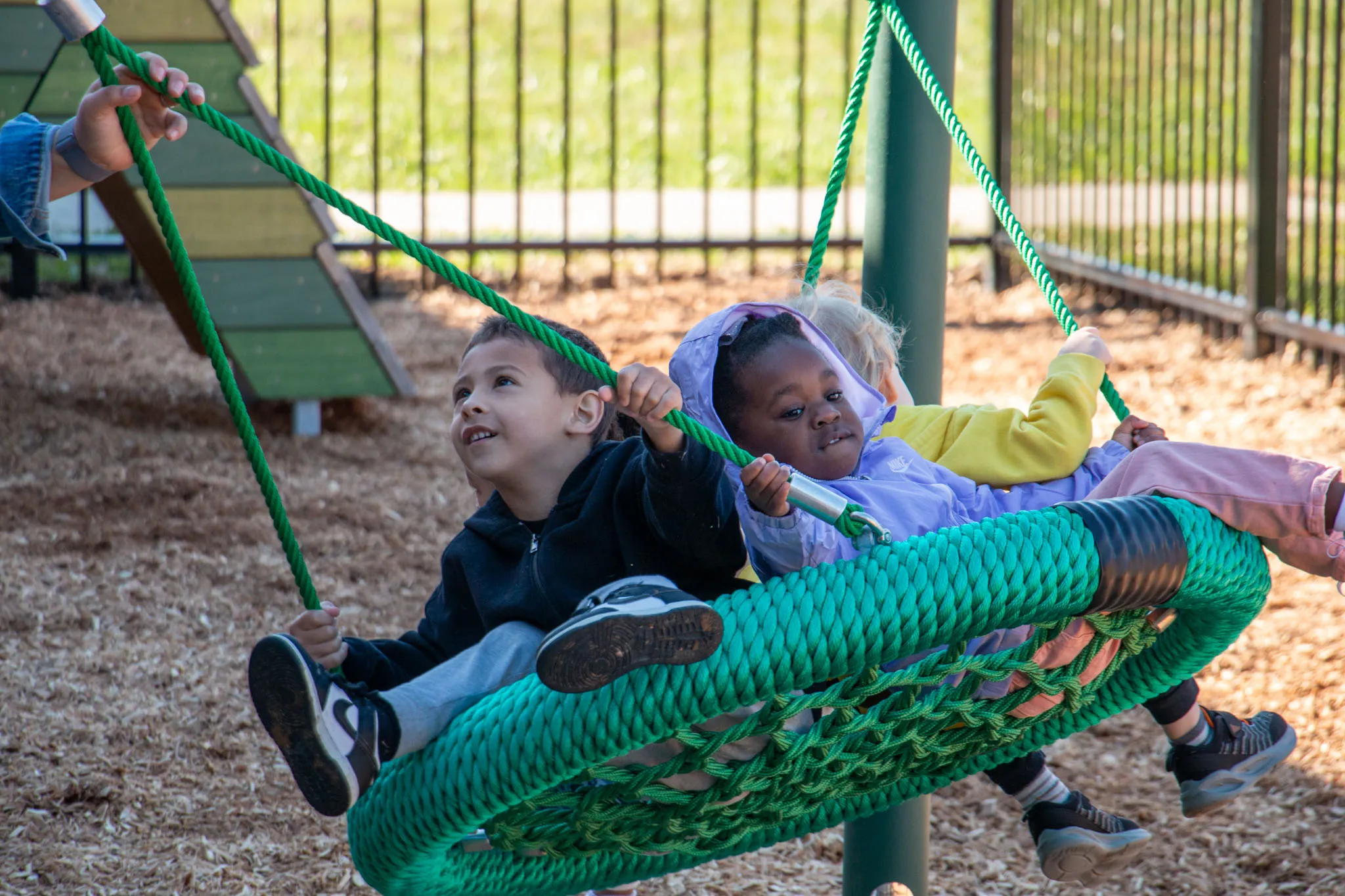 Two youths enjoying the new swing at the playground at the Hilltop YMCA.