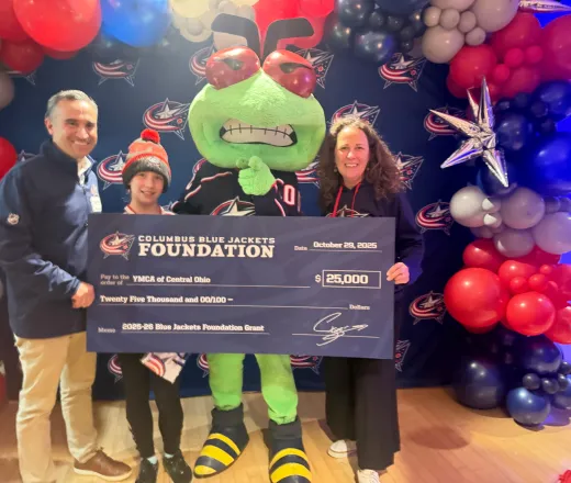 CEO Tony Collins and CDO, Melissa Garver, accept investment as large check from CBJ Foundation with mascot Stinger