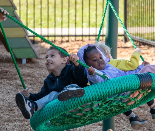 pre-k students enjoy the ADA-accessible swing at their new Nature Playscape at the Hilltop YMCA