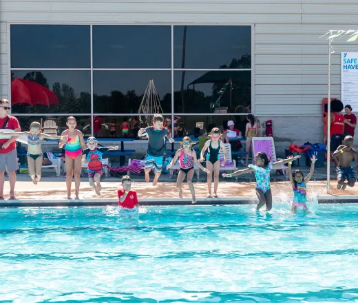 kids jump into pool together at YMCA summer day camp