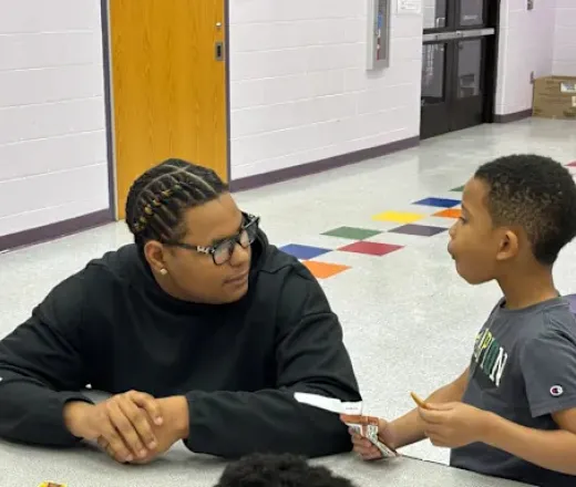 High school senior Logan Booker works with a student during Y-Club at Slate Ridge Elementary