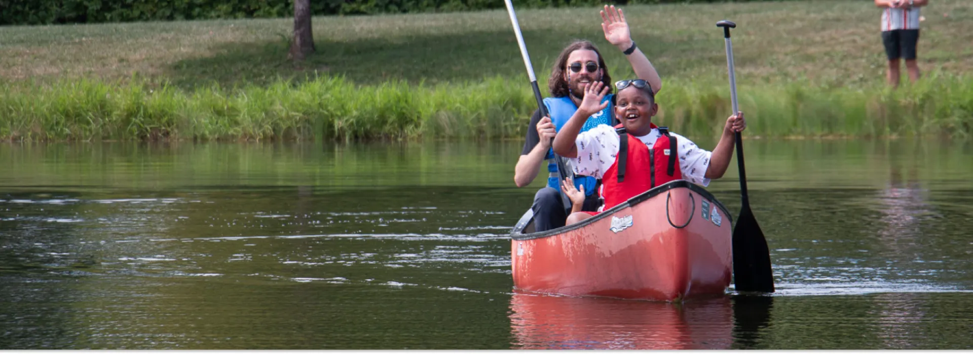 Grove City Family Fun a boy with a YMCA staff member enjoying the canoe and water